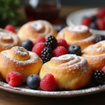 Freshly baked Resurrection Rolls with powdered sugar and berries, ready to serve.