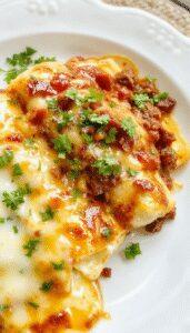 Close-up of plated healthy cheesy ground beef enchiladas featuring golden-brown tortillas filled with seasoned ground beef and melted cheese, garnished with fresh cilantro, served on a rustic plate with vibrant red sauce drizzled on top.