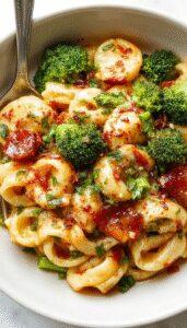 A vibrant plate of broccoli pasta featuring al dente spaghetti topped with bright green steamed broccoli florets and a sprinkle of grated cheese, garnished with fresh herbs. The dish is served on a white plate with a rustic wooden table backdrop, highlighting the colorful ingredients and inviting presentation.