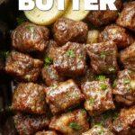 A close-up shot of tender, golden-brown beef bites glazed with garlic butter, arranged neatly on a rustic ceramic plate with fresh herbs sprinkled on top. The beef has a juicy, succulent appearance with a slight caramelized crust, highlighting its juicy interior and savory coating, served alongside colorful vegetables and garnished with chopped parsley.