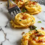 A vibrant plate of Marry Me Tortellini featuring golden-brown, stuffed tortellini arranged in a circular pattern on a white ceramic plate. The tortellini are coated in a glossy sauce, garnished with fresh chopped herbs, and accompanied by a side of cherry tomatoes and parsley for color contrast. The background showcases a rustic wooden table with a hint of grated cheese and a drizzle of olive oil, evoking an inviting, homey Italian meal setting.