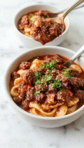 A rich, deep-brown beef ragu served over wide pasta noodles in a rustic white bowl, garnished with freshly chopped herbs, with steam gently rising, set on a wooden table with a rustic backdrop.