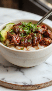A vibrant pepper steak rice bowl featuring sliced bell peppers, ground beef, and fluffy rice, topped with a sprinkle of fresh herbs, arranged elegantly in a white bowl with colorful ingredients contrasting vividly against a rustic wooden table background.